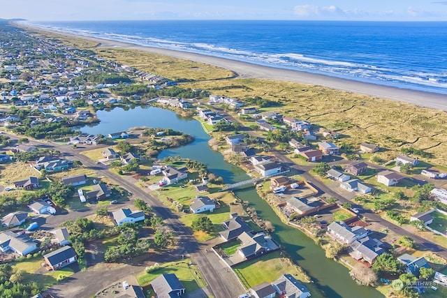 birds eye view of property with a water view and a beach view