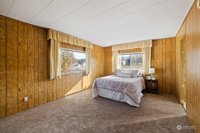 carpeted bedroom featuring wooden walls