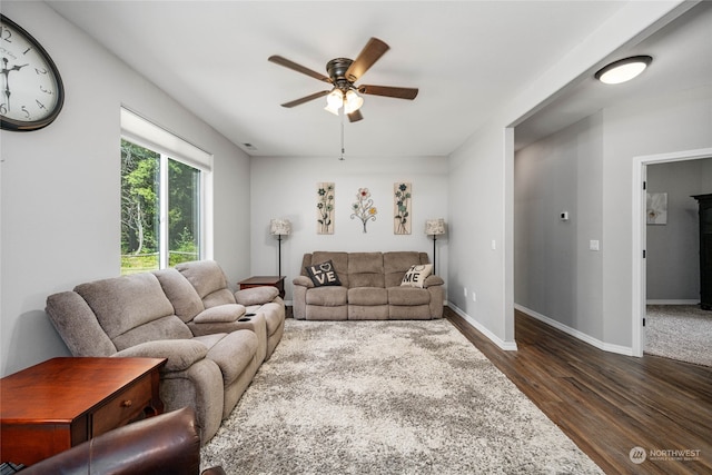 living room featuring ceiling fan and dark hardwood / wood-style floors