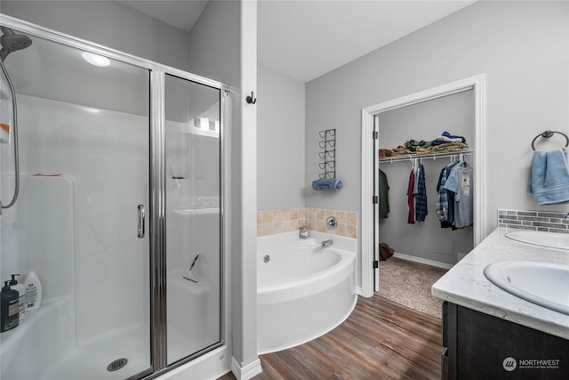 bathroom featuring shower with separate bathtub, hardwood / wood-style flooring, and vanity