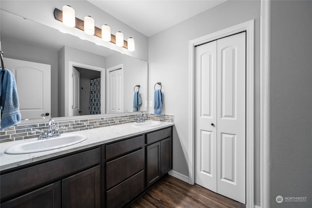 bathroom with wood-type flooring, vanity, and backsplash