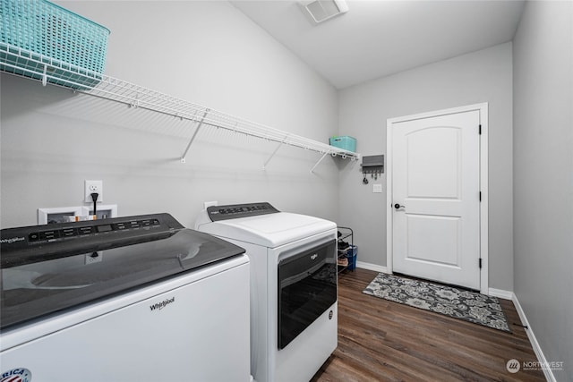 clothes washing area with separate washer and dryer and dark wood-type flooring