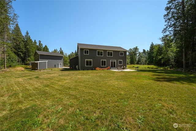 rear view of property with a yard and a patio area