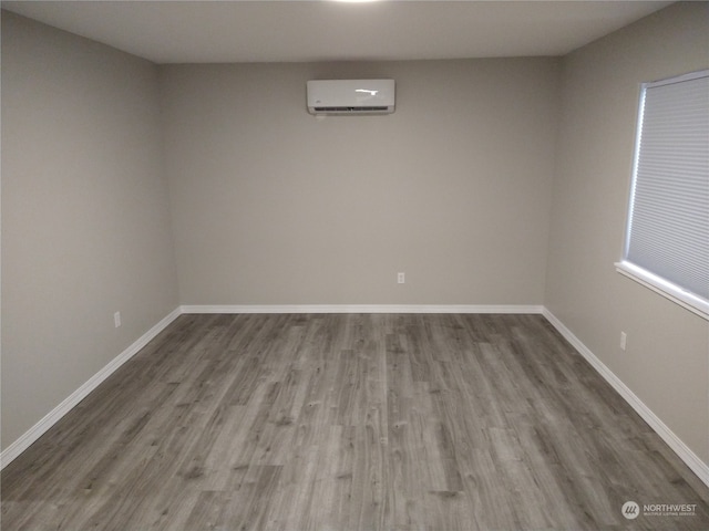 empty room featuring wood-type flooring and a wall mounted AC