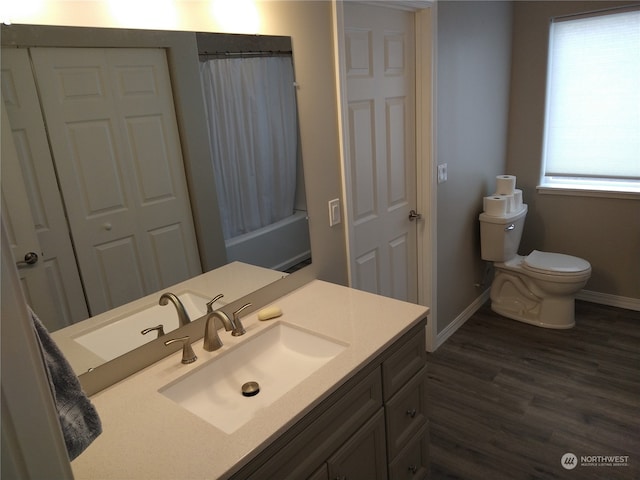 full bathroom with shower / tub combo with curtain, hardwood / wood-style flooring, vanity, and toilet