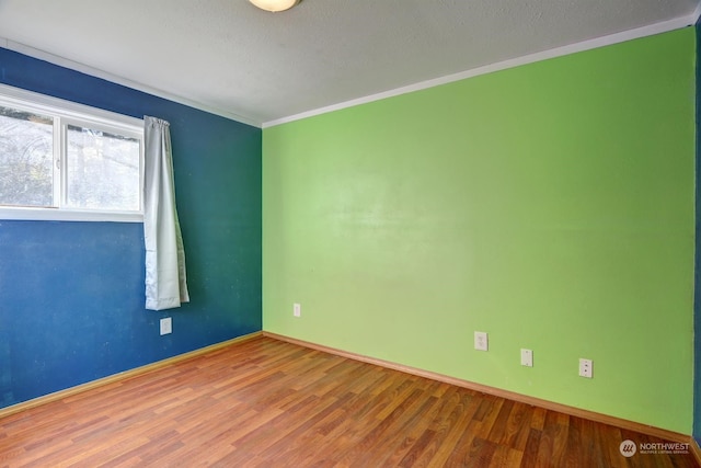 spare room featuring ornamental molding, hardwood / wood-style flooring, and a textured ceiling