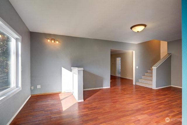 empty room with plenty of natural light and hardwood / wood-style floors