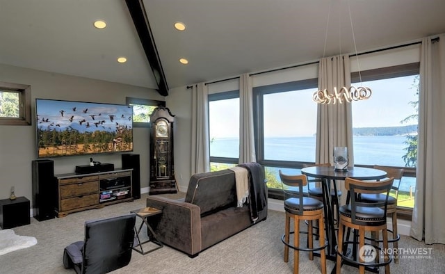 living room with a wealth of natural light, a water view, and light colored carpet