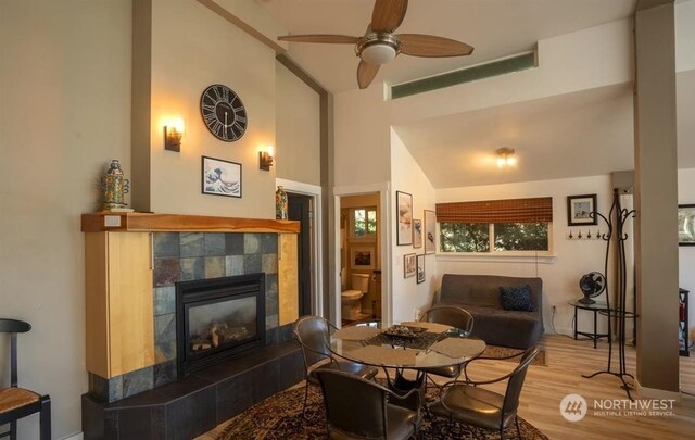 96 Forrest Rd, Sequim, WA 98382 - dining area with wood finished floors, a tiled fireplace, ceiling fan, and high vaulted ceiling