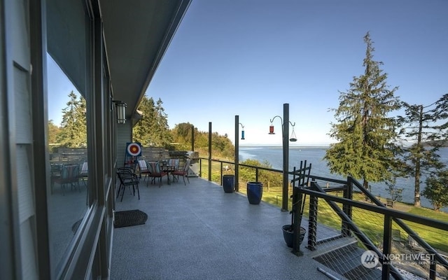 view of patio / terrace with a balcony and a water view