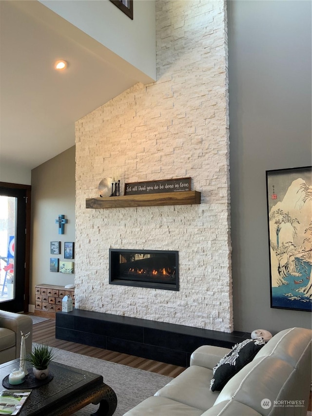 living room featuring hardwood / wood-style flooring, a fireplace, and vaulted ceiling