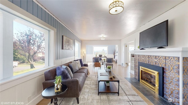 713 N Broadway St, Aberdeen, WA 98520 - living area featuring a tiled fireplace, a wainscoted wall, and a decorative wall