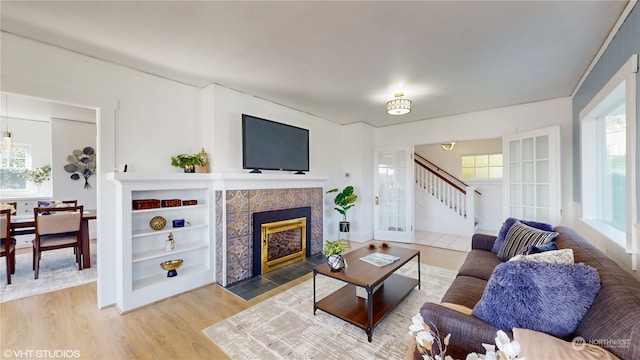 living room featuring a tile fireplace and wood-type flooring