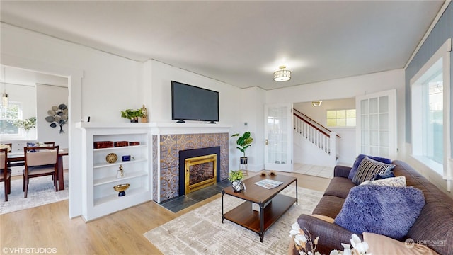713 N Broadway St, Aberdeen, WA 98520 - living room featuring a fireplace with flush hearth, wood finished floors, and stairway