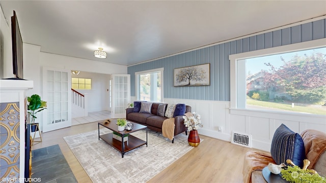 living room featuring plenty of natural light, french doors, and hardwood / wood-style floors