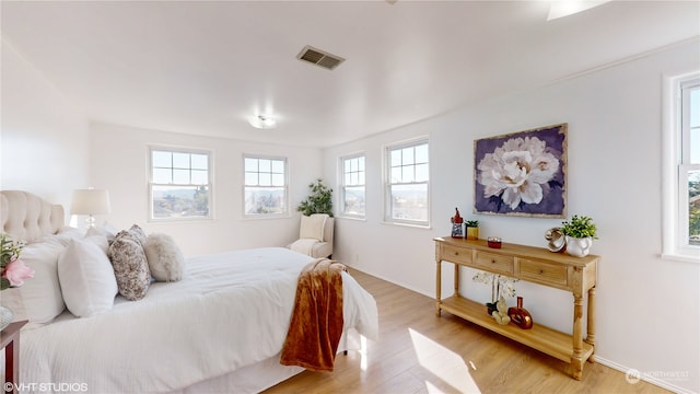 bedroom featuring multiple windows and light hardwood / wood-style flooring