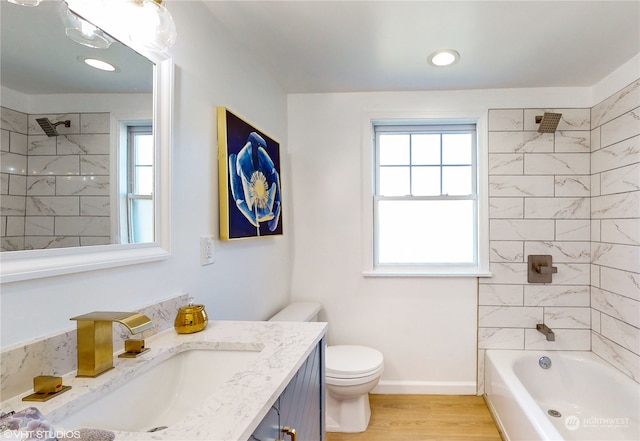 full bathroom featuring a healthy amount of sunlight, wood-type flooring, and tiled shower / bath combo