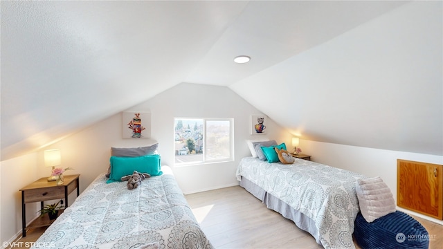 bedroom with light hardwood / wood-style floors and vaulted ceiling