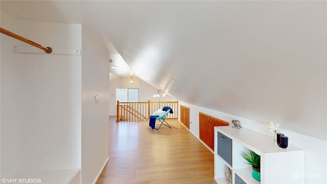 additional living space with lofted ceiling and light hardwood / wood-style floors