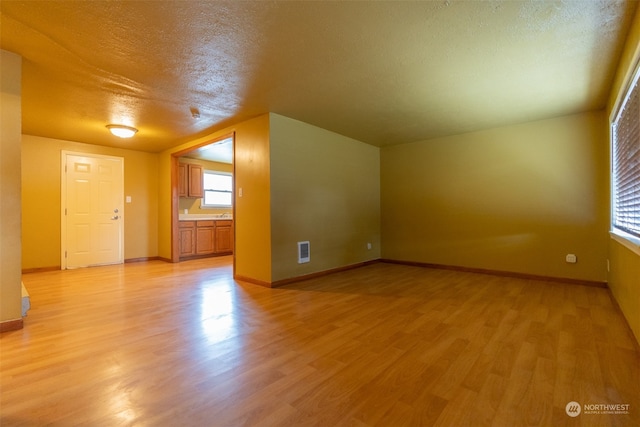 bonus room featuring a textured ceiling and light hardwood / wood-style floors