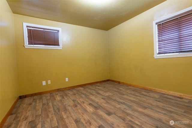 unfurnished room with dark wood-type flooring