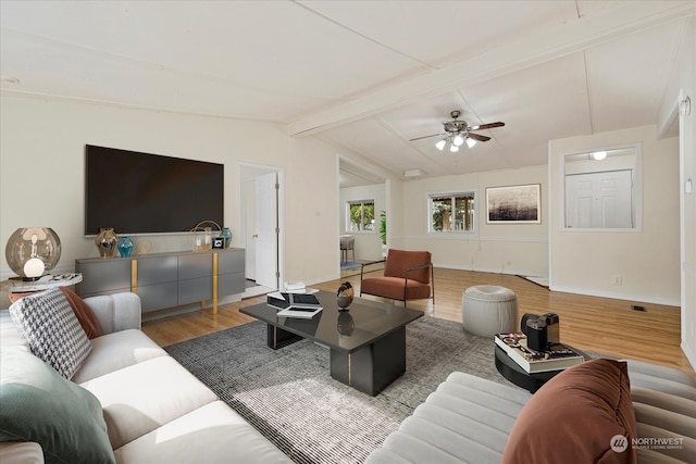 living room featuring ceiling fan, vaulted ceiling with beams, and hardwood / wood-style floors