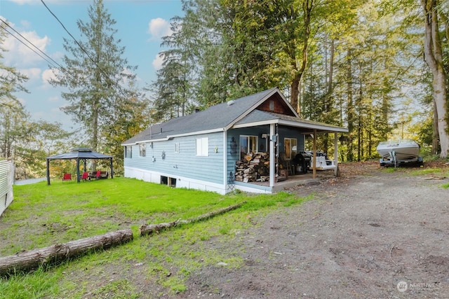 view of side of home featuring a gazebo and a yard