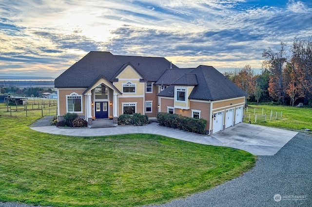 view of front of property with a garage and a lawn