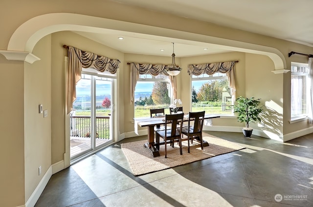 dining area featuring decorative columns and a wealth of natural light