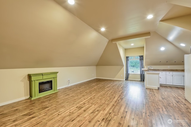 bonus room featuring lofted ceiling, sink, and light hardwood / wood-style floors