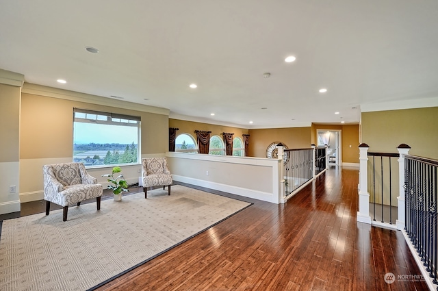 living area with crown molding and dark hardwood / wood-style floors