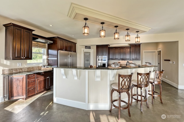 kitchen with appliances with stainless steel finishes, concrete flooring, hanging light fixtures, and a kitchen island