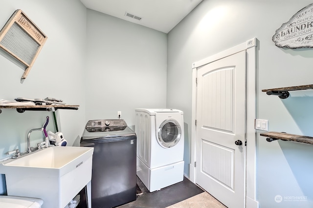 washroom with sink and washing machine and clothes dryer