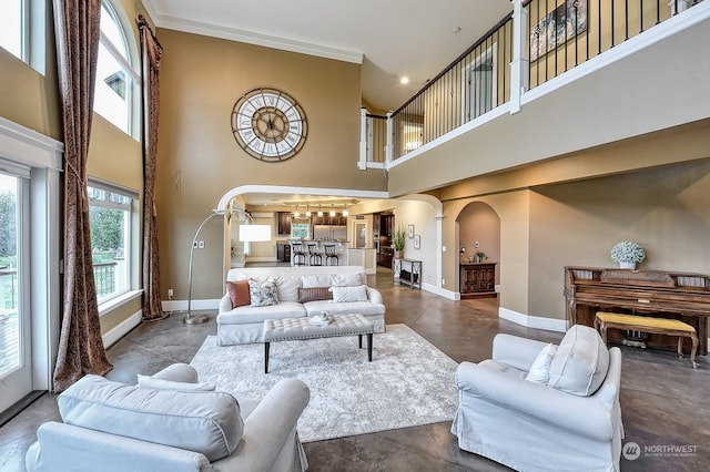 living room with crown molding, a towering ceiling, and concrete flooring