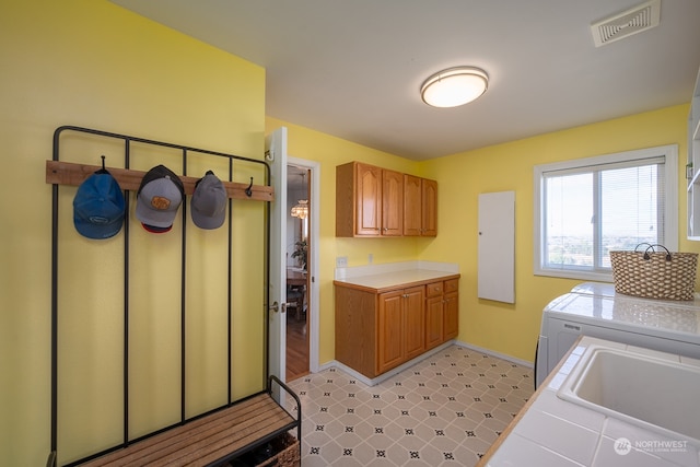 kitchen featuring sink, washer and clothes dryer, and tile counters