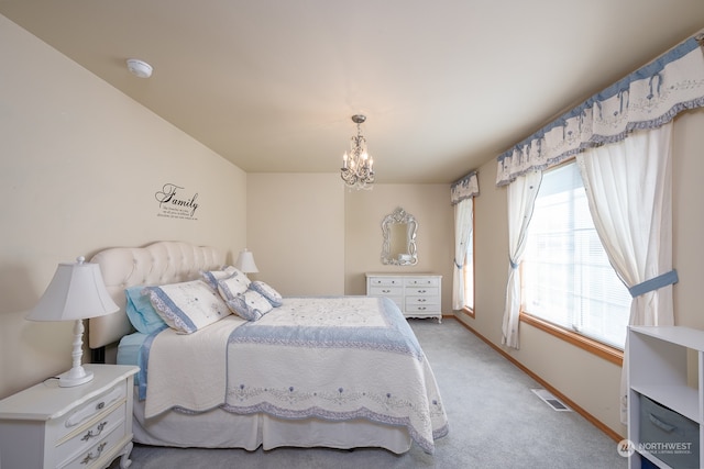 carpeted bedroom with an inviting chandelier