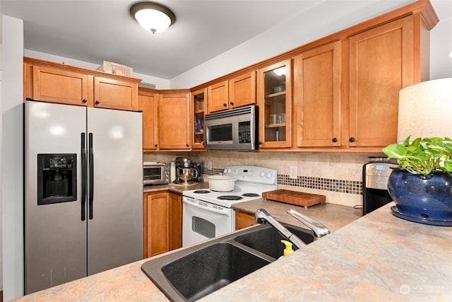 kitchen featuring backsplash, appliances with stainless steel finishes, and sink