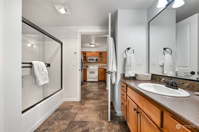 bathroom with bath / shower combo with glass door and vanity