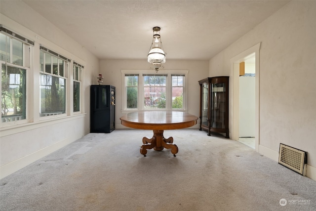 unfurnished dining area featuring light colored carpet