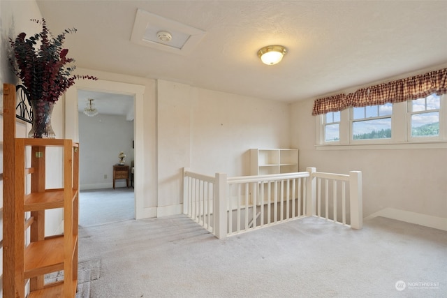 hall featuring a textured ceiling and light colored carpet