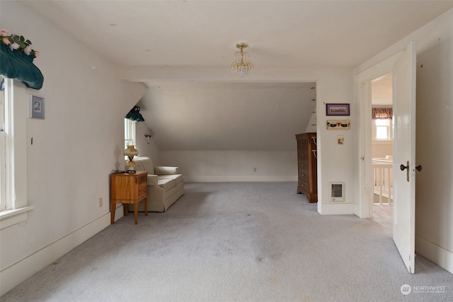 bonus room with light colored carpet and vaulted ceiling