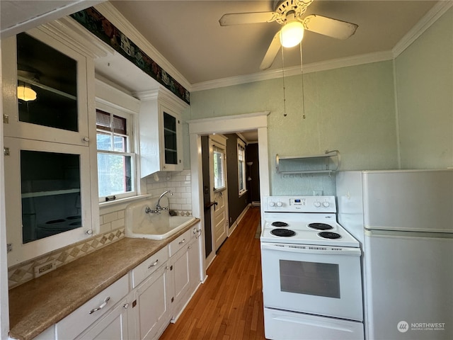 kitchen with light wood-type flooring, white appliances, backsplash, and white cabinets