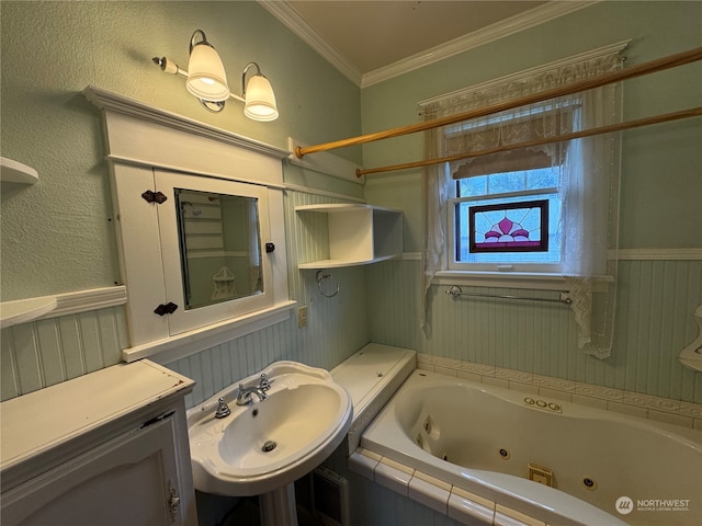 bathroom with ornamental molding, a relaxing tiled tub, and sink