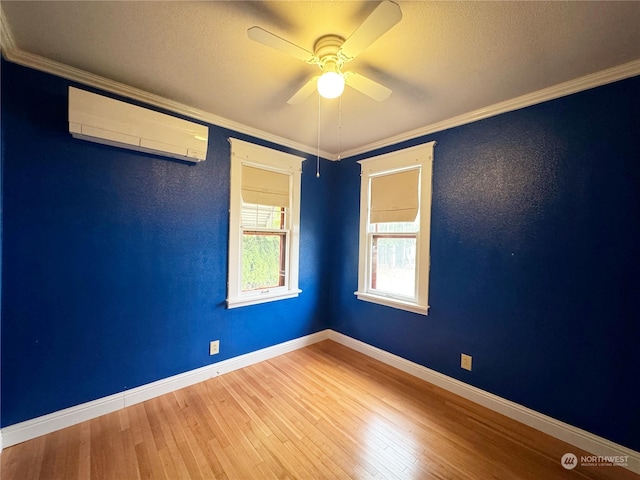 unfurnished room with wood-type flooring, a wall mounted AC, ornamental molding, and ceiling fan