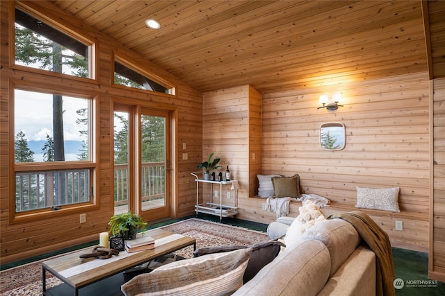 living room with wood ceiling, high vaulted ceiling, a wealth of natural light, and wooden walls