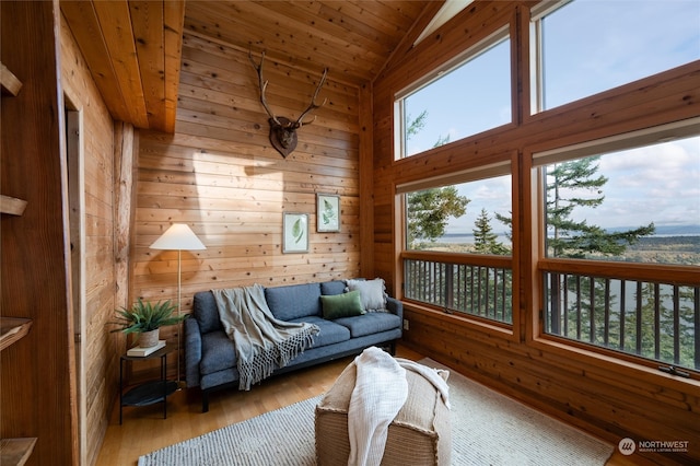 interior space featuring light hardwood / wood-style floors, wood walls, and lofted ceiling