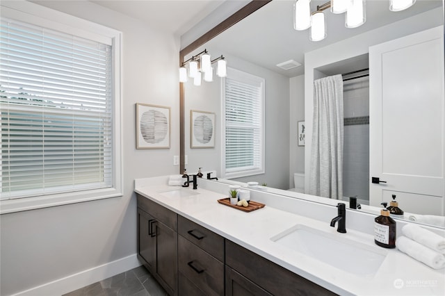 bathroom with walk in shower, a healthy amount of sunlight, vanity, and toilet