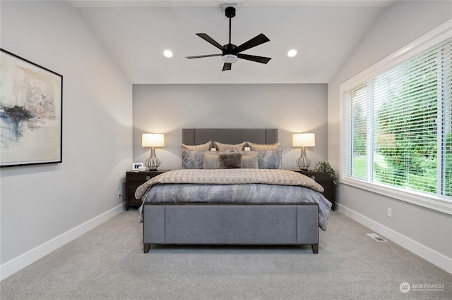 bedroom with lofted ceiling, light colored carpet, multiple windows, and ceiling fan