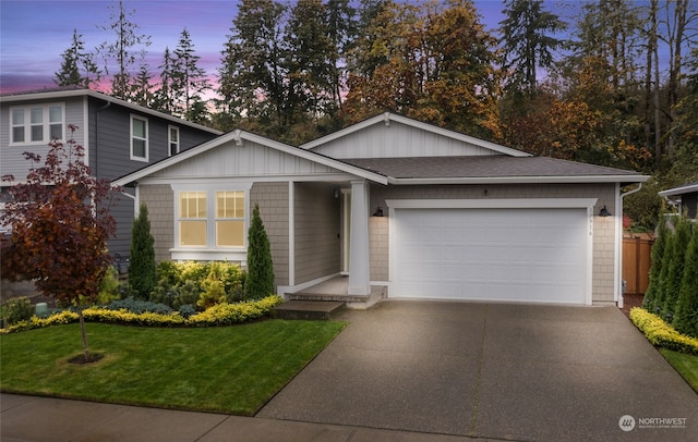 view of front of home with a garage and a yard