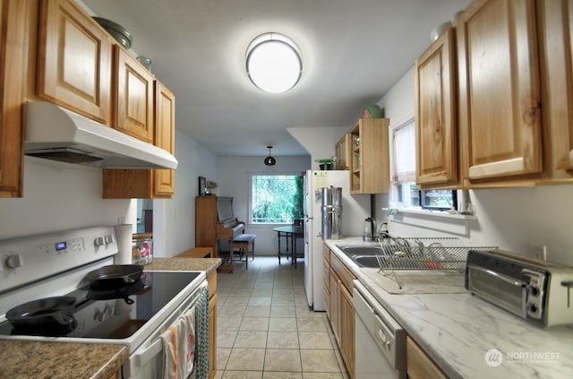 kitchen featuring a wealth of natural light, white appliances, and light tile patterned floors